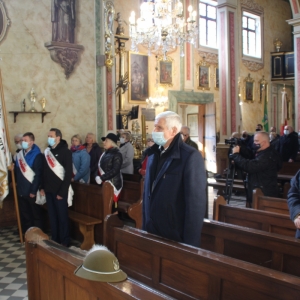 Zdjęcie w kościele, ludzie w maseczkach uczestniczący we mszy. Na przodzie trzech mężczyzn stojących ze sztandarem, mają na sobie szarfy Solidarność.